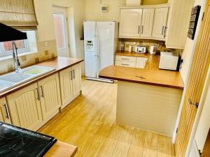 a kitchen with wooden floors and a white refrigerator at Spacious & modern 3 bedroom house in Peterlee in Wingate