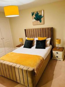 sypialnia z dużym łóżkiem z żółtą pościelą i poduszkami w obiekcie Spacious & modern 3 bedroom house in Peterlee w mieście Wingate