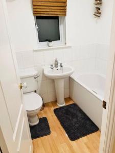 y baño con aseo, lavabo y bañera. en Spacious & modern 3 bedroom house in Peterlee en Wingate