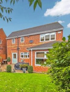 uma casa de tijolos com um relvado em frente em Spacious & modern 3 bedroom house in Peterlee em Wingate