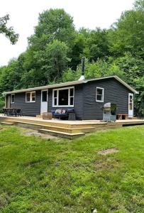 a small black house with a porch and a yard at The perfect getaway cabin in Washington