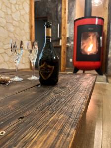 eine Flasche Wein auf einem Holztisch mit Weingläsern in der Unterkunft Apartment Chalet mit Kamin in Plauen