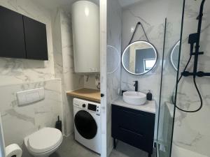 a bathroom with a sink and a toilet and a mirror at Appartement Cosy - Disney Paris in Chalifert