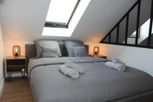 1 dormitorio con 1 cama con 3 almohadas en Appartement Cosy - Disney Paris en Chalifert