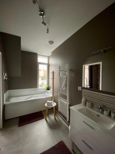 a bathroom with a tub and a sink at APPARTEMENT KENNEDY in Boulogne-sur-Mer