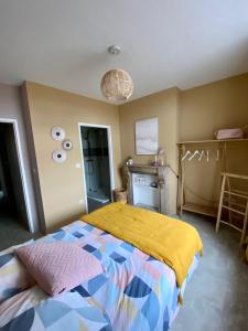 a bedroom with a bed with a yellow blanket at APPARTEMENT KENNEDY in Boulogne-sur-Mer