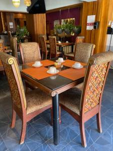 einen Holztisch und Stühle in einem Restaurant in der Unterkunft HOTEL LAGOS INN in Lagos de Moreno