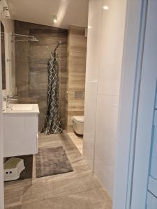 a bathroom with a shower and a sink and a toilet at Apartament Baltic Park - BEL MARE 2 in Pogorzelica +14 photos