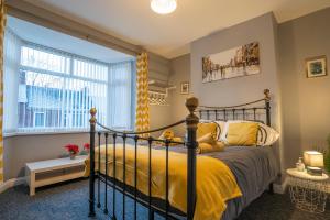 a bedroom with a bed with yellow sheets and a window at 12 Minutes to Centre-Near A1-Parking in Swalwell