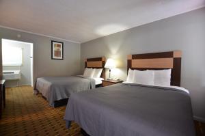 a hotel room with two beds and a window at Travelowes Motel - Maggie Valley in Maggie Valley
