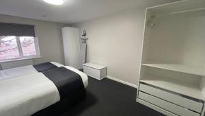 a bedroom with a bed and a book shelf at Hosted By Ryan - 1 Bedroom Apartment in Liverpool