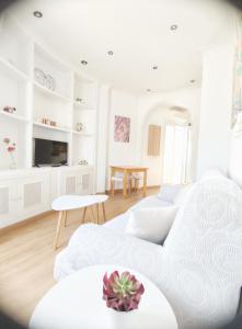 - un salon blanc avec un canapé et une table dans l'établissement Apartamento Hermosilla, à Malaga