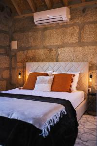 a bedroom with a large white bed with orange pillows at Retiros do Vale in Vila Real