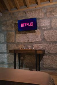 a sign that reads netflix on a brick wall at Retiros do Vale in Vila Real