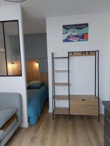 1 dormitorio con cama y espejo en Studio la Salicorne au Sables d'Olonne, en Les Sables-dʼOlonne