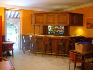 a bar in a restaurant with wooden cabinets and stools at Hôtel Les Palmiers in Saint-Tropez