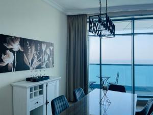 une salle à manger avec une table et des chaises en verre dans l'établissement Beachfront paradise just minutes from Dubai, à Ajman