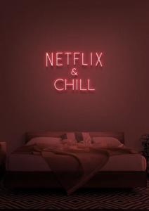 a neon sign that says netflix and chill in a bedroom at The Tal-Y-Cafn Hotel in Tal-y-Cafn