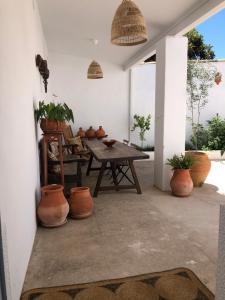 a patio with a wooden table and potted plants at El Granado in Piedrabuena