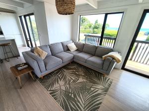 uma sala de estar com um sofá e uma mesa em Pohara's Seaside Accommodation em Pohara