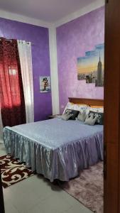 a bedroom with a bed with purple walls at Casa vacanze in Mombarcaro