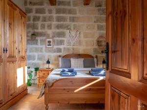 a bedroom with a bed and a stone wall at Sunny Villa in Nadur