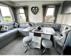 a living room with a couch and a table and chairs at Hazel grove - Withernsea Sands in Waxholme