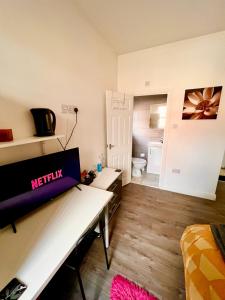 uma sala de estar com televisão numa mesa num quarto em Deluxe En-suite room in CV1 em Coventry