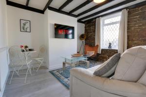 uma sala de estar com um sofá e uma mesa em Cozy 2-bedroom house in Sheffield em Tankersley