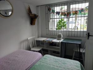 een kamer met een bed, een tafel en een raam bij ANNANDA in Florianópolis
