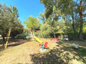 a park with a playground with a swing at Les Gîtes du Petit Mas in Lagamas