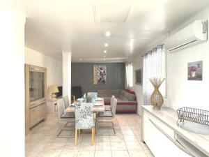 a dining room and living room with a table and chairs at Les Gîtes du Petit Mas in Lagamas