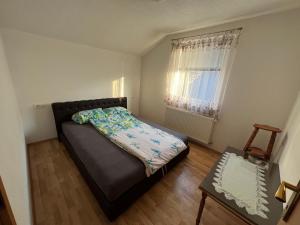 a small bedroom with a bed and a window at Apartmani Piramida Mjeseca i Sunca in Visoko