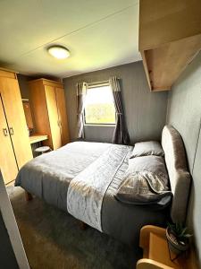 Un dormitorio con una cama grande y una ventana en Hazel grove - Withernsea Sands, en Waxholme