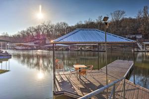 a dock with two chairs and a table on the water at Pet-Friendly Grand Lake House with Dock and Kayaks! in Eucha