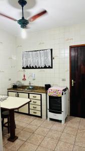 Casa em frente ao mar - Condominio في كاراغواتاتوبا: مطبخ فيه طاولة ومايكرويف
