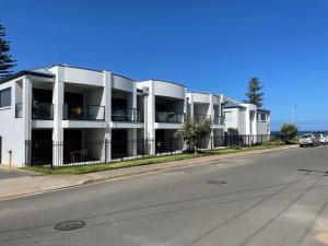 a white apartment building on the side of a street at Moana Seaside Retreat in Moana