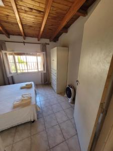 1 dormitorio con 1 cama y nevera en Departamento Hermoso en Tupungato en Tupungato