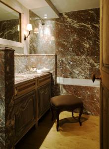 a bathroom with a sink and a stool next to a mirror at Relais Bourgondisch Cruyce, A Luxe Worldwide Hotel in Bruges