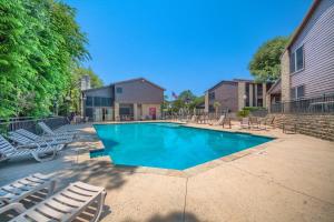 a swimming pool with lounge chairs and a house at CW CH Camp Warnecke Club Haus in New Braunfels