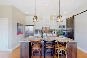 a kitchen with a large island with four bar stools at Barber Valley Beauty in Boise