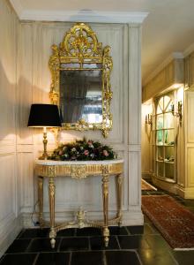 a large mirror in a room with a table and a dresser at Relais Bourgondisch Cruyce, A Luxe Worldwide Hotel in Bruges