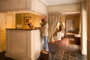 Due donne in piedi al bancone in una stanza di Relais Bourgondisch Cruyce, A Luxe Worldwide Hotel a Bruges