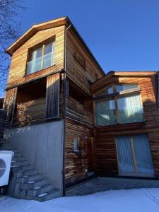 a wooden house with stairs in front of it at Ferienhaus Lumnezia Lux in Cumbels