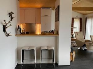 a kitchen with two stools next to a counter at Ferienhaus Lumnezia Lux in Cumbels
