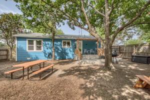 a blue house with a picnic table and a tree at DT 534 Castle Shadow Cottage in New Braunfels