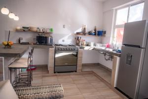 a kitchen with a stove and a sink and a refrigerator at Tu cabaña Cuernavaca - hospedaje by Arcadia in Cuernavaca