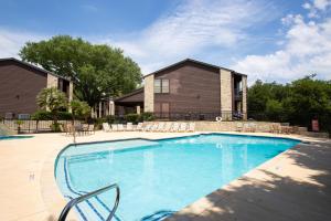 a swimming pool with chairs in front of a house at CW B203 Tubers Delight in New Braunfels