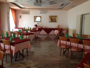 a room with tables and chairs with green candles on them at Park Hotel Gianfranco in Roccella Ionica