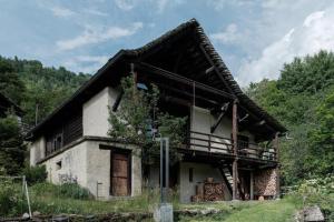 an old house with a porch and a balcony at La Stalla - Mid-Century Rustico in Calpiogna
